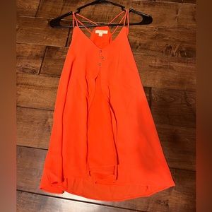 E&M bright orange flowy tank top with sheer material in the back.